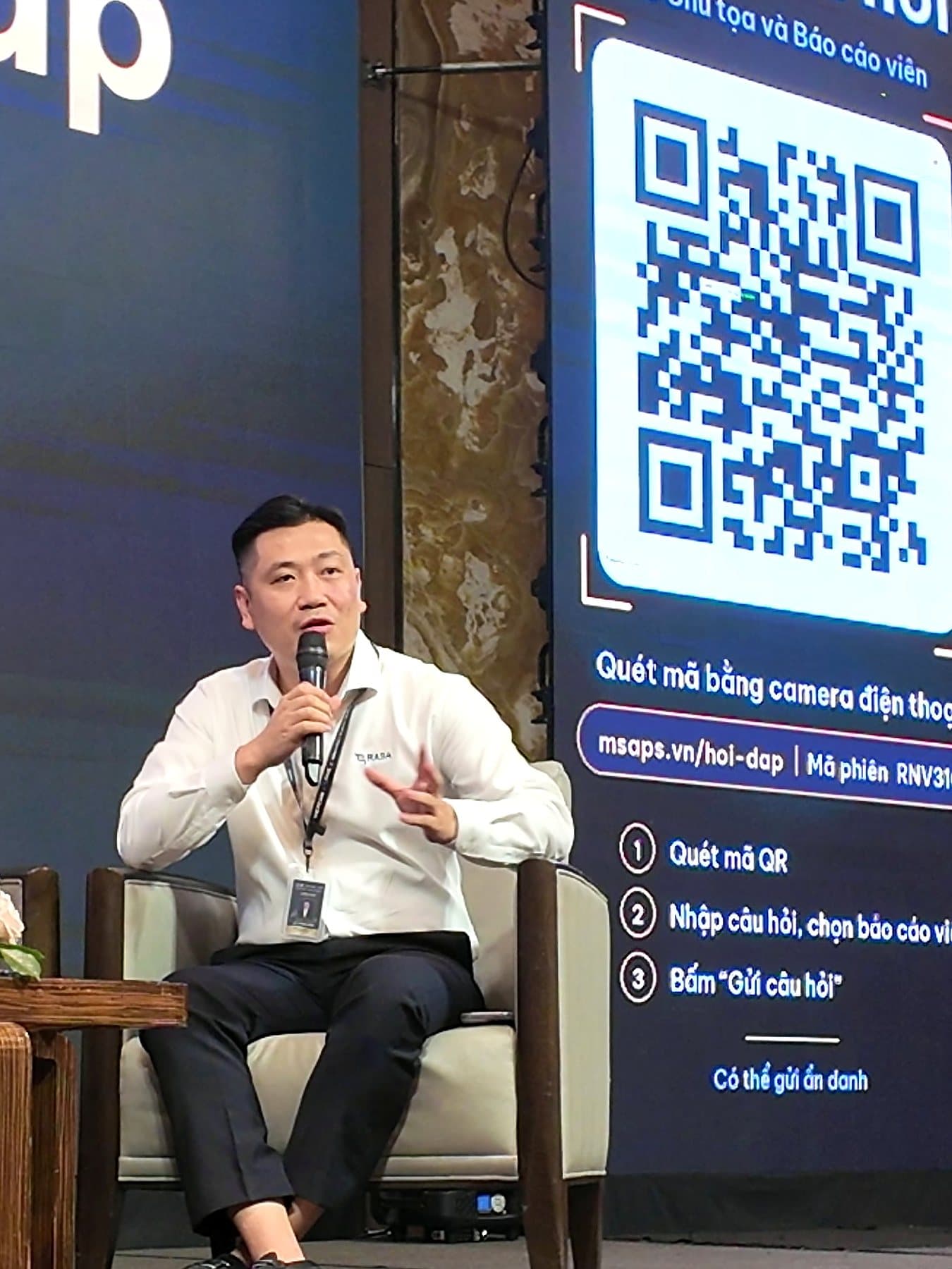 BS.CKII. Lê Trung Kiên trả lời câu hỏi tại phiên thảo luận, phía sau là mã QR đặt câu hỏi